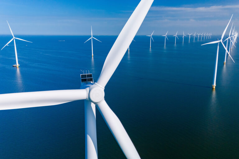 Close up of offshore wind turbine and other wind turbines with Ultra High Performance Concrete (UHPC) foundations from Y-MatTec in the background at Vesterhav